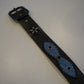 Vintage studded black leather belt detail showing pyramid stud pattern and worn vintage finish.