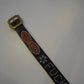 Vintage studded belt close-up showing orange Fuck Off graphic and silver pyramid studs on aged black leather