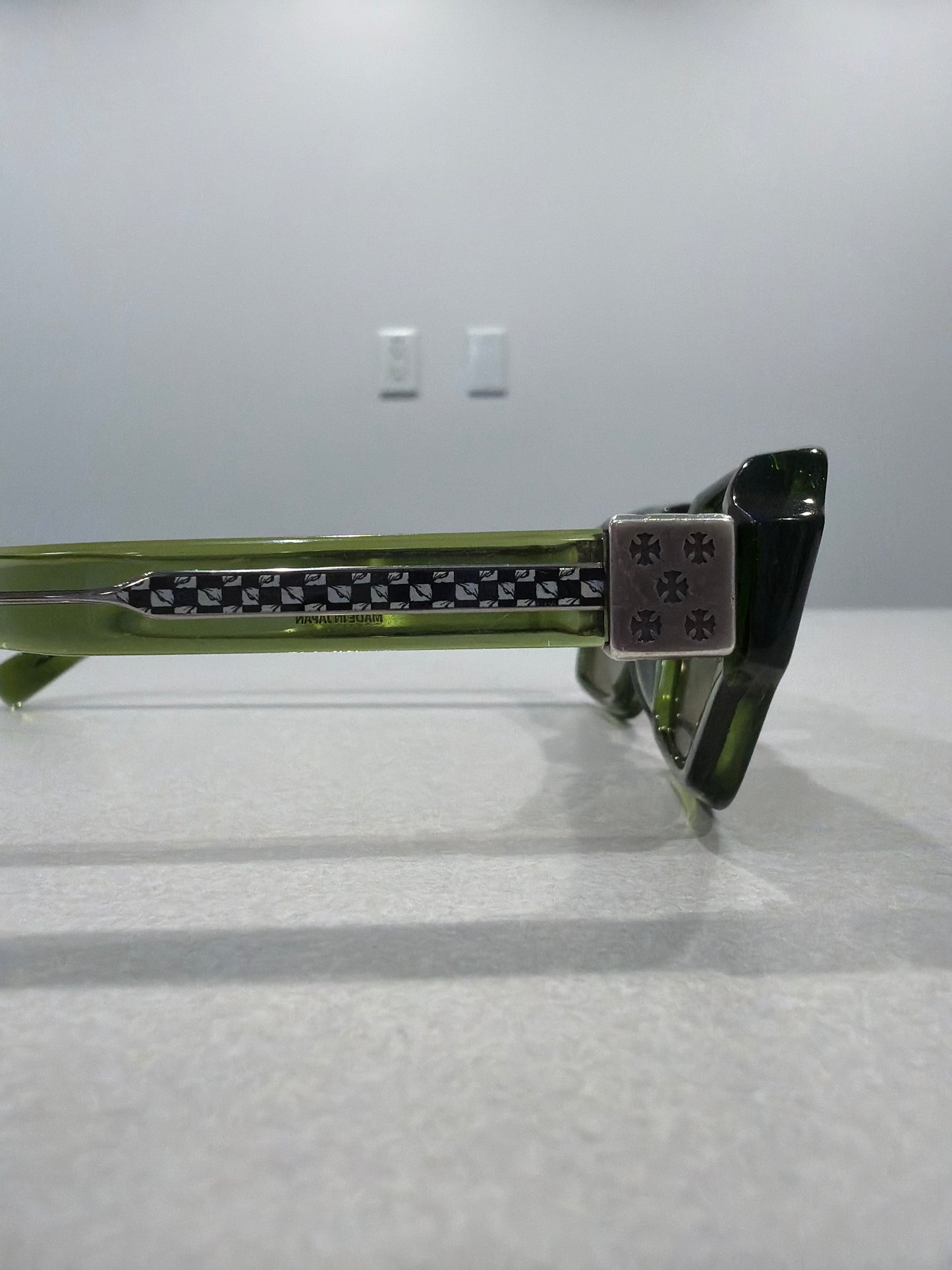 Chrome Hearts Matty Boy green sunglasses temple detail showing silver cross hardware and Made in Japan stamp