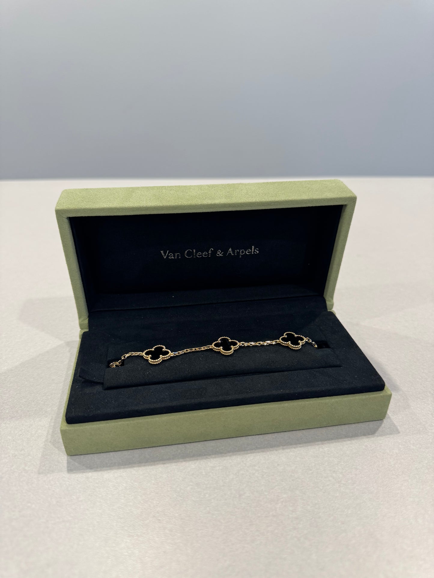 Van Cleef & Arpels onyx Alhambra bracelet close-up of 5 clover motifs in 18k yellow gold chain