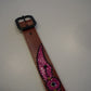 Vintage winged studded leather belt detail showing pink snakeskin texture and metal stud accents.