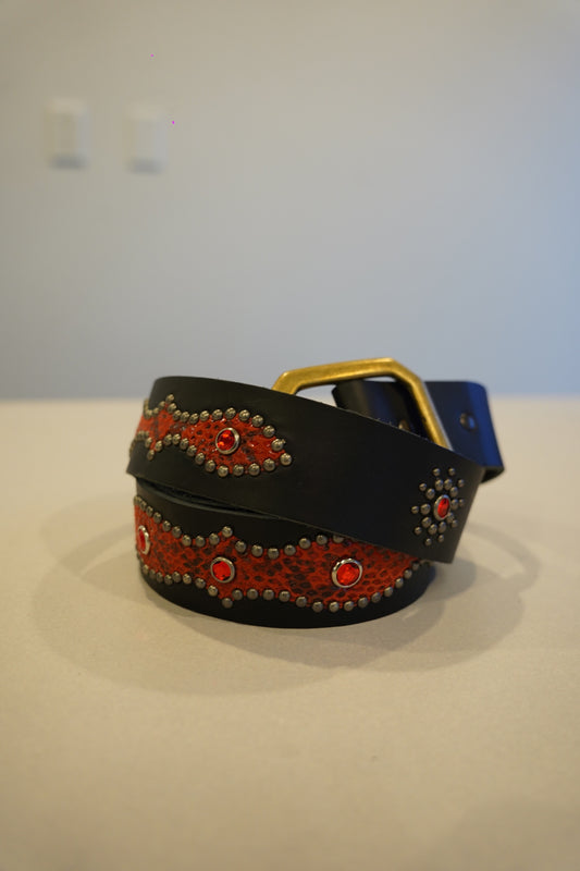 Vintage snakeskin studded leather belt coiled view with black red embossed scales and silver pyramid studs