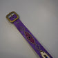 Vintage purple snakeskin studded leather belt close-up showing brass buckle and beaded medallion detail