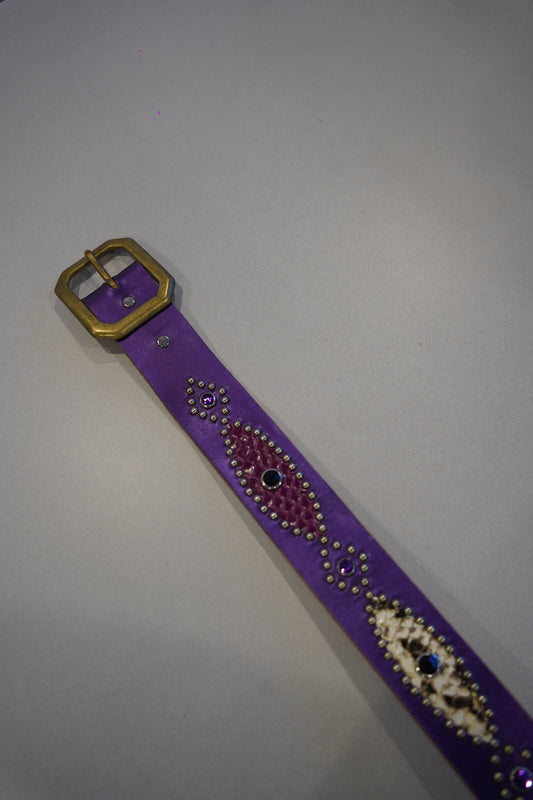 Vintage purple snakeskin studded leather belt close-up showing brass buckle and beaded medallion detail