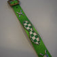 Vintage green checkered studded belt close-up detail of metal buckle and pyramid stud row