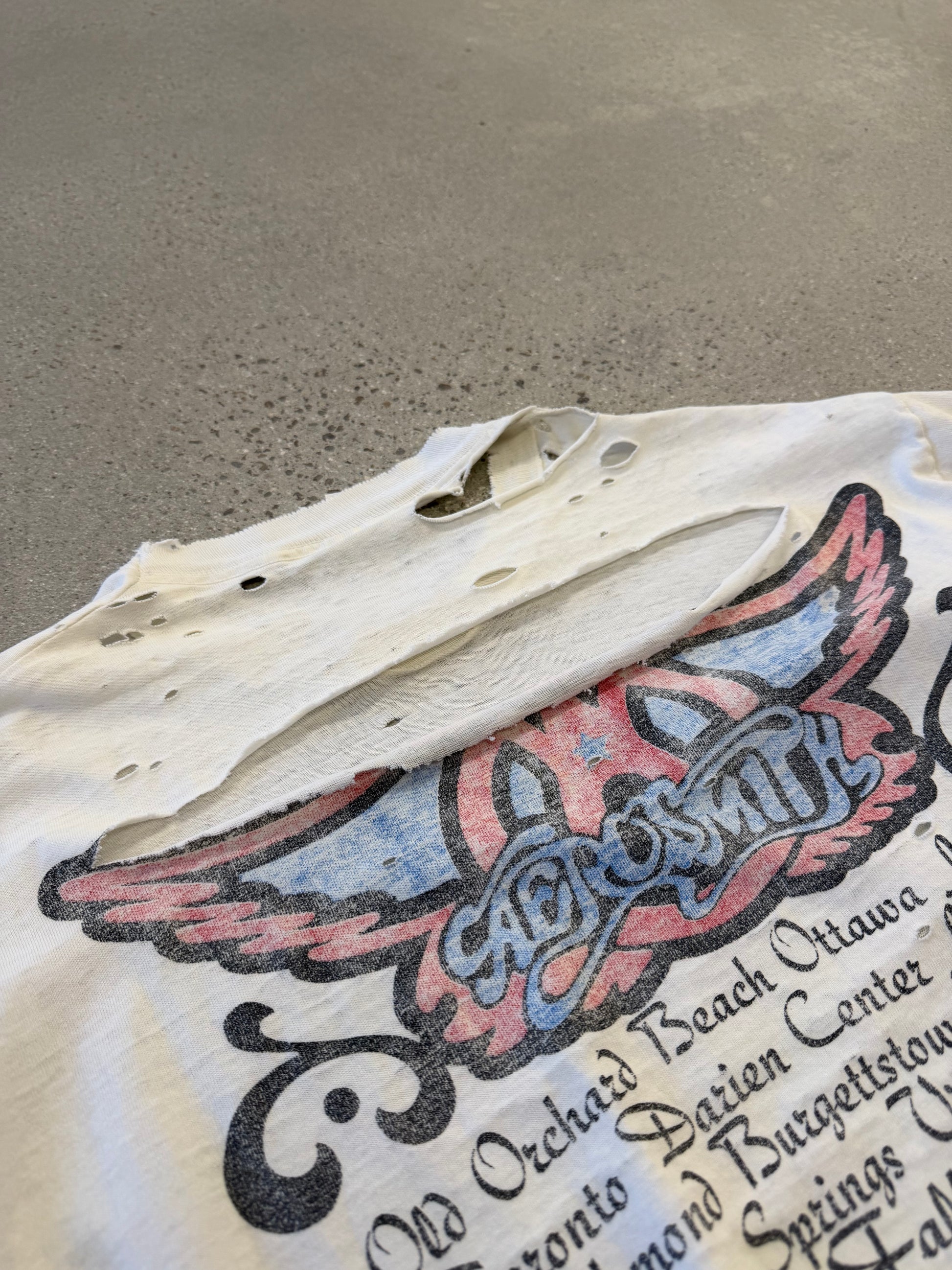 Aerosmith Nine Lives vintage tour tee detail showing faded graphic print and worn black cotton fabric.