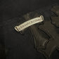 Chrome Hearts carpenter shorts macro view of silver Chrome Hearts scroll plaque among black leather cross patches
