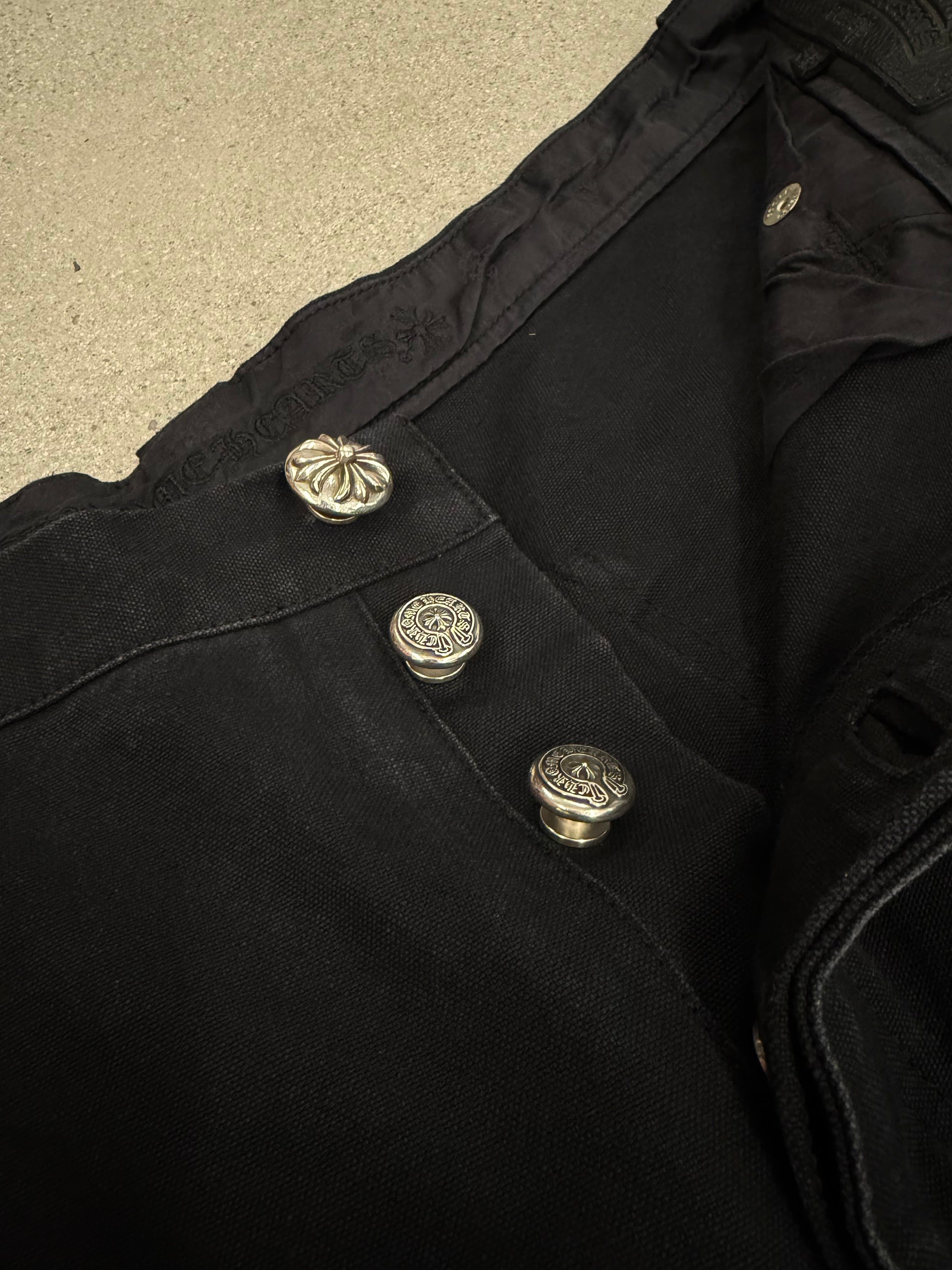 Chrome Hearts carpenter shorts waistband detail with three silver cross-engraved button closures