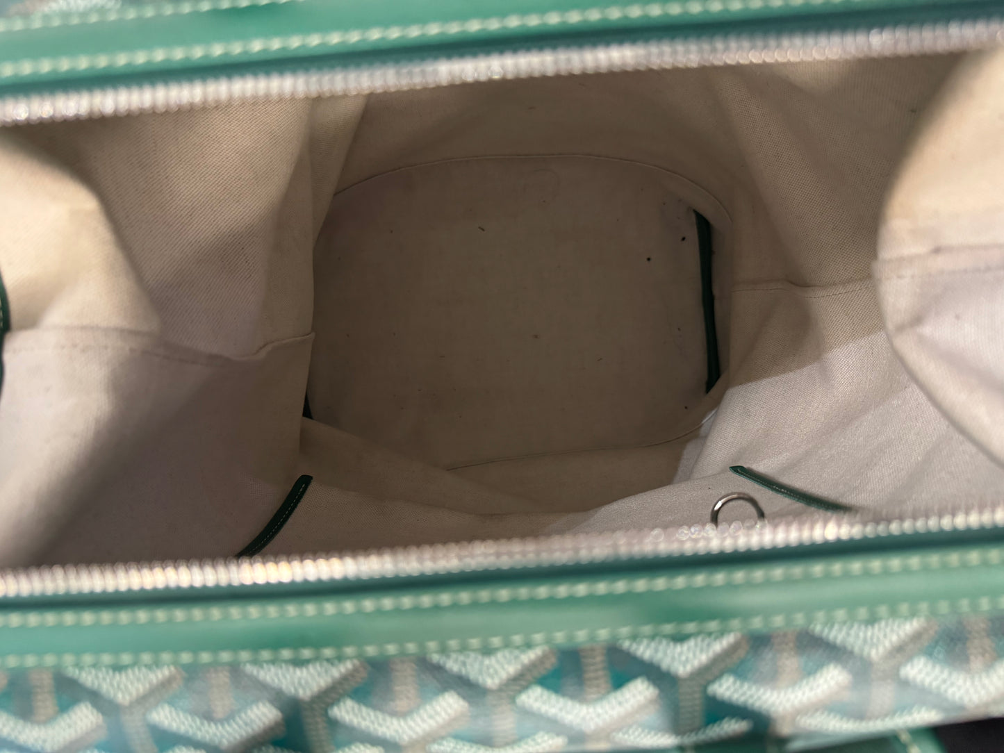 Goyard Cisalpin backpack interior, white canvas lining trimmed with green Goyardine chevron edging.