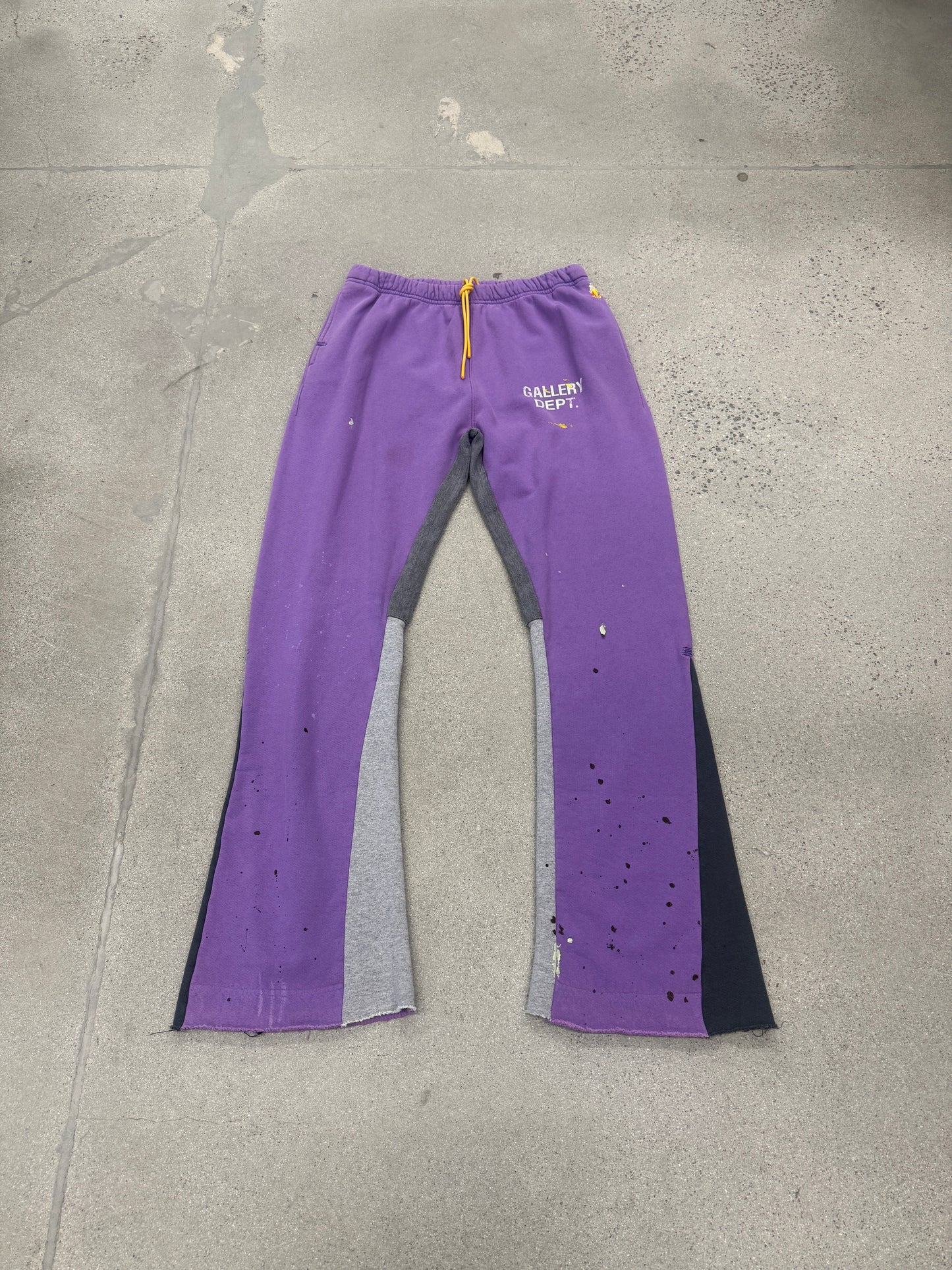 Gallery Dept purple painted flare sweatpants laid flat, showing flared hem and signature paint-splattered finish
