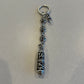 Chrome Hearts Celtic dagger key ring close-up view of engraved silver capsule pendant and beaded links