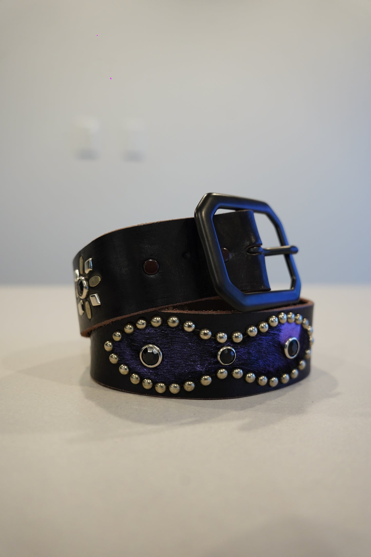 Vintage black leather belt coiled with purple ponyhair studded oval inlay and black square buckle