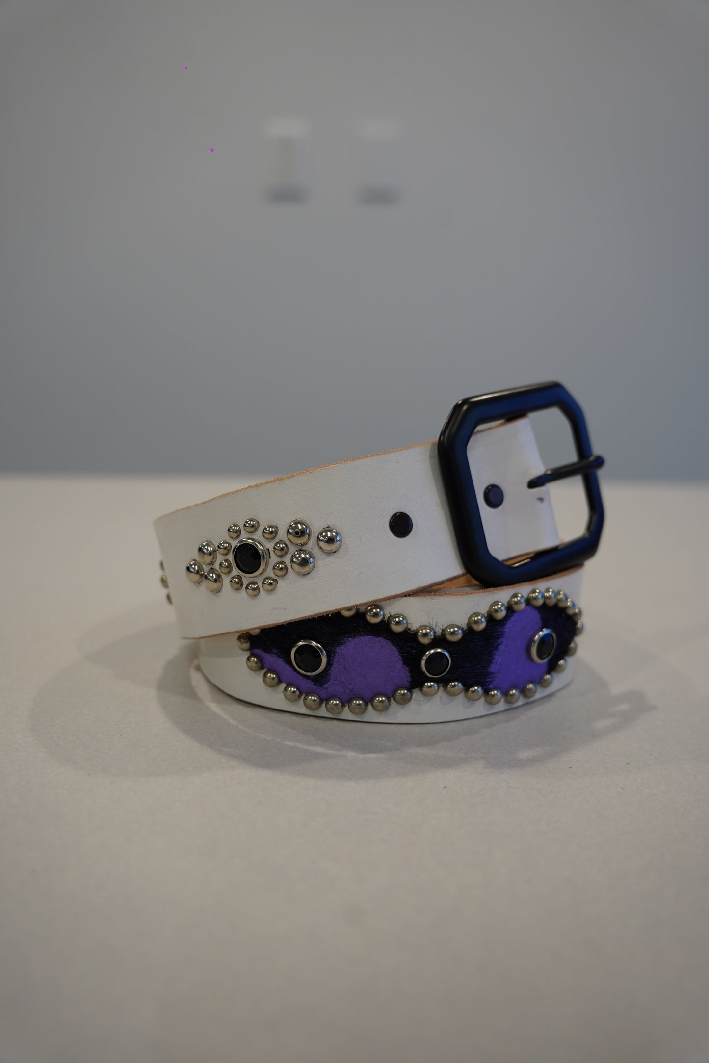 Vintage white leather belt with purple pony hair triple cross panel and silver pyramid stud accents.