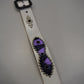 Studded leather belt detail showing purple pony hair inset, silver studs and antique brass buckle hardware.