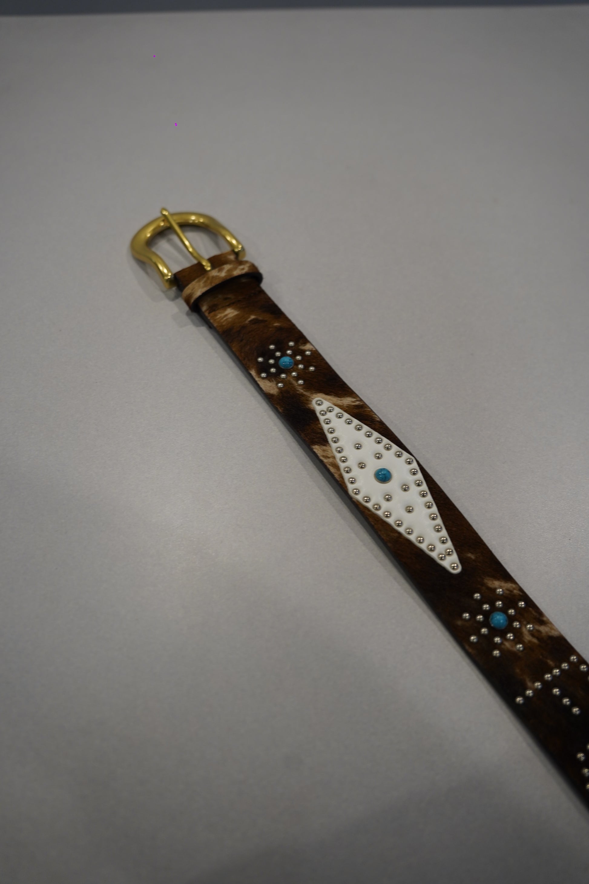 Custom cowhide FU belt full length view showing pyramid stud pattern and aged brown leather strap.
