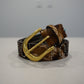 Custom studded brown leather belt detail of horseshoe buckle with turquoise inlay and silver conchos.