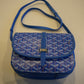 Goyard Belvedere PM blue chevron canvas bag close-up of GOYARD engraved name plate and leather strap attach.