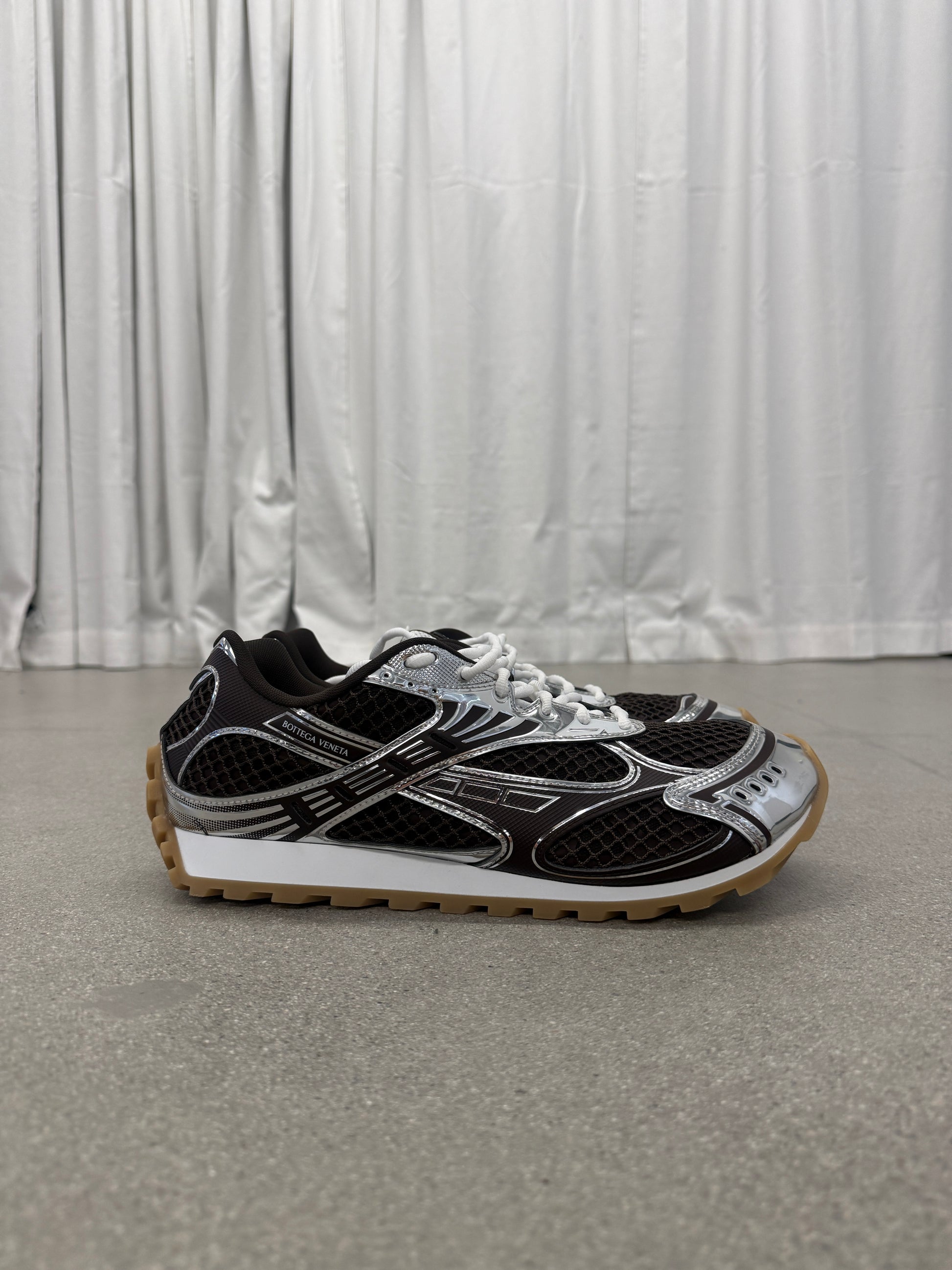 Bottega Veneta brown Orbit sneakers side profile with mesh upper, silver chrome overlays and gum rubber sole