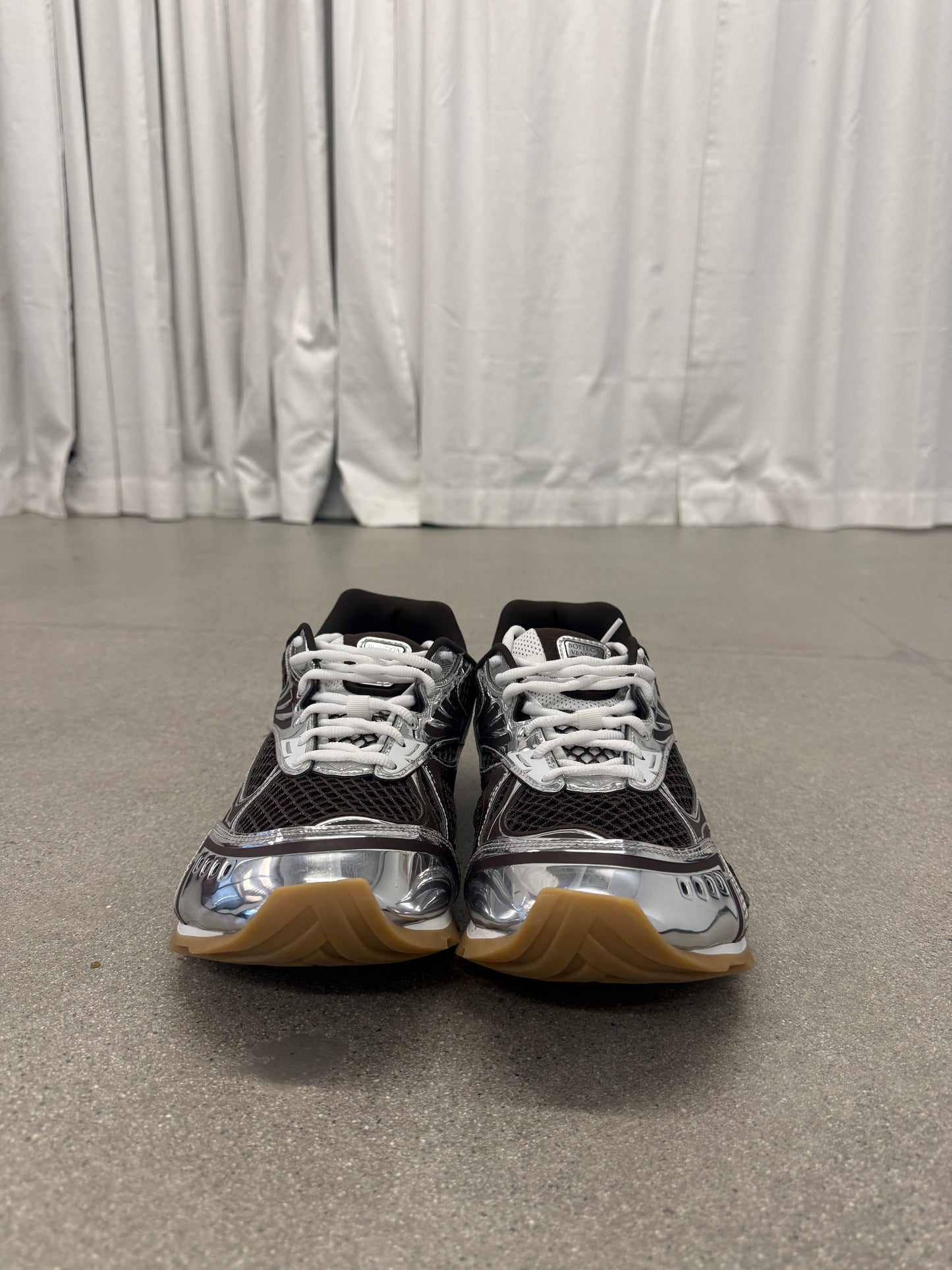 Bottega Veneta Orbit brown sneakers front view with white laces, mesh tongue and chrome silver detailing