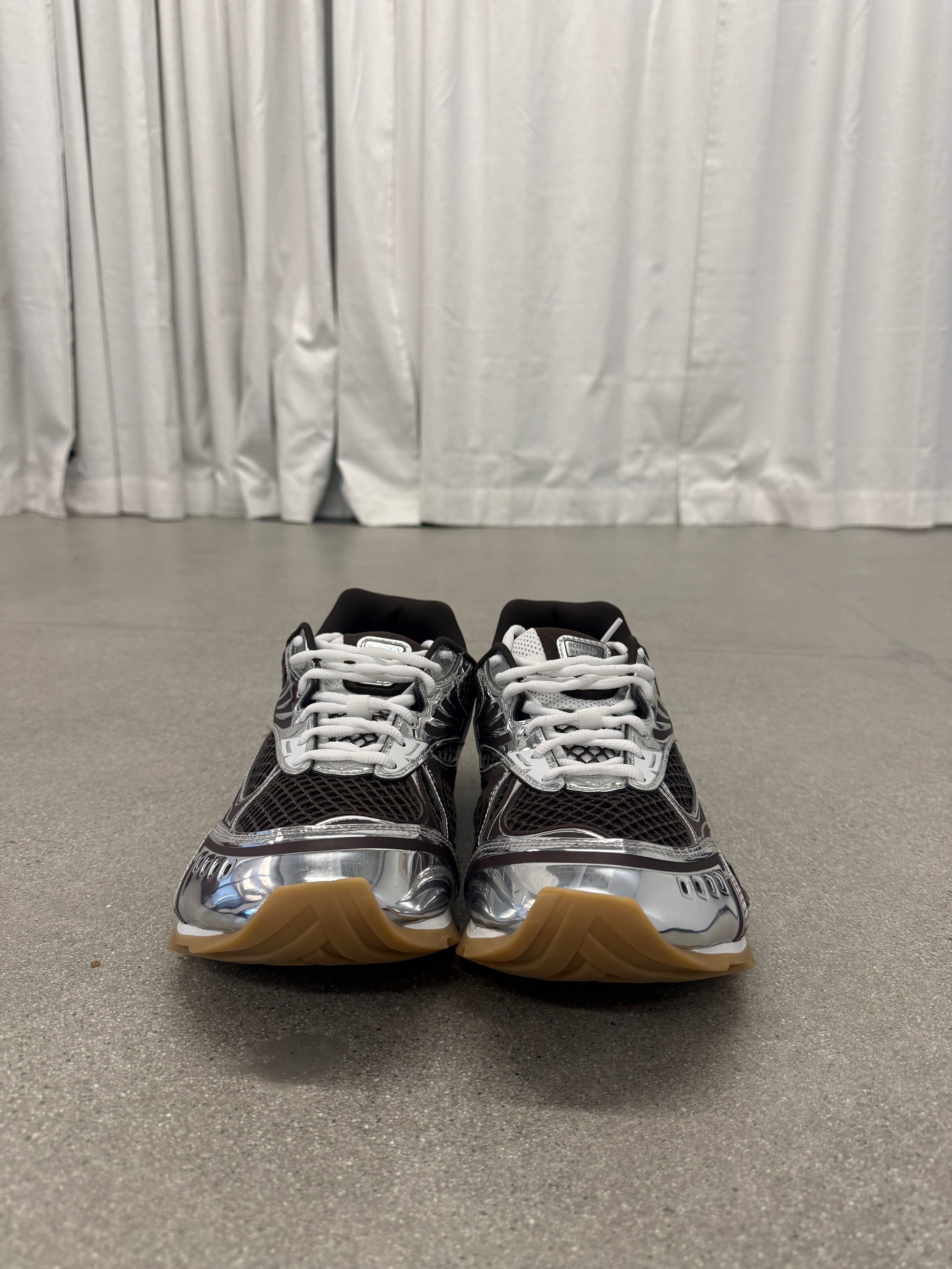 Bottega Veneta Orbit brown sneakers front view with white laces, mesh tongue and chrome silver detailing