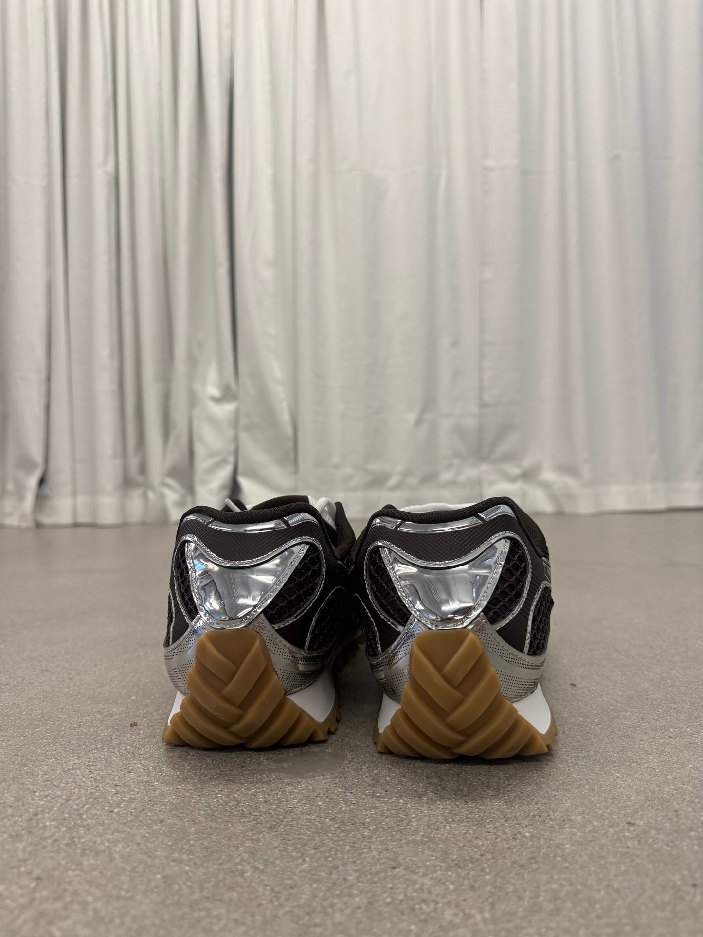 Bottega Veneta Orbit sneakers heel view showing chrome silver counter and stacked gum rubber outsole