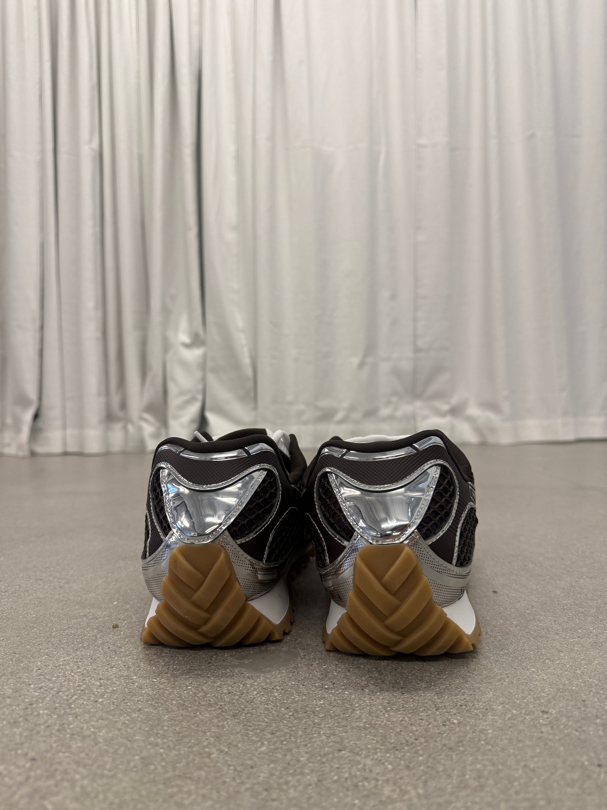 Bottega Veneta Orbit sneakers heel view showing chrome silver counter and stacked gum rubber outsole
