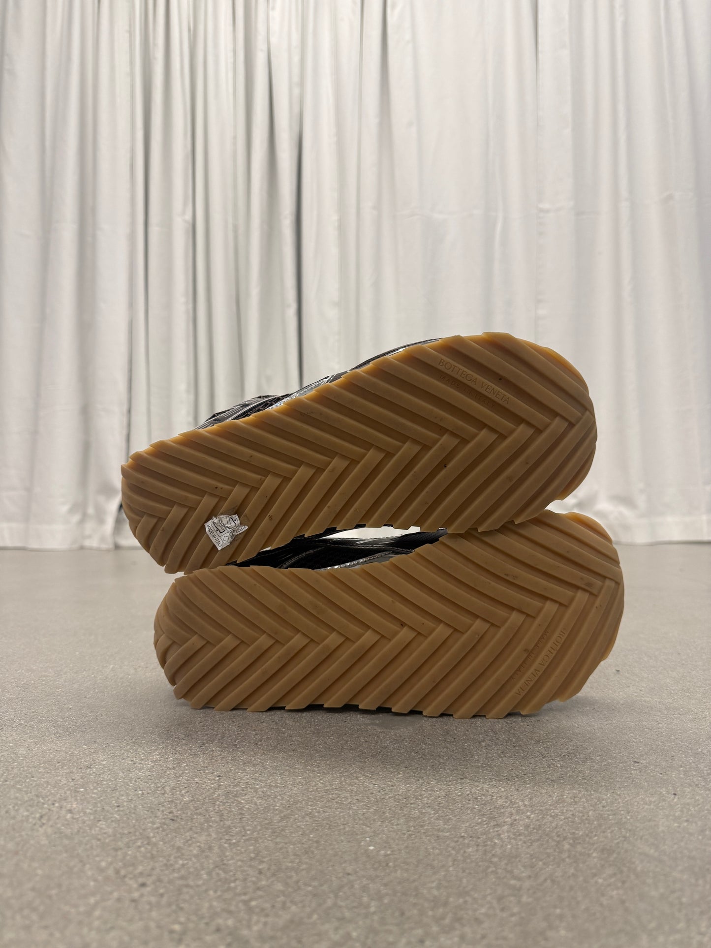 Bottega Veneta Orbit sneakers paired bottom view of woven chevron gum rubber outsole tread pattern