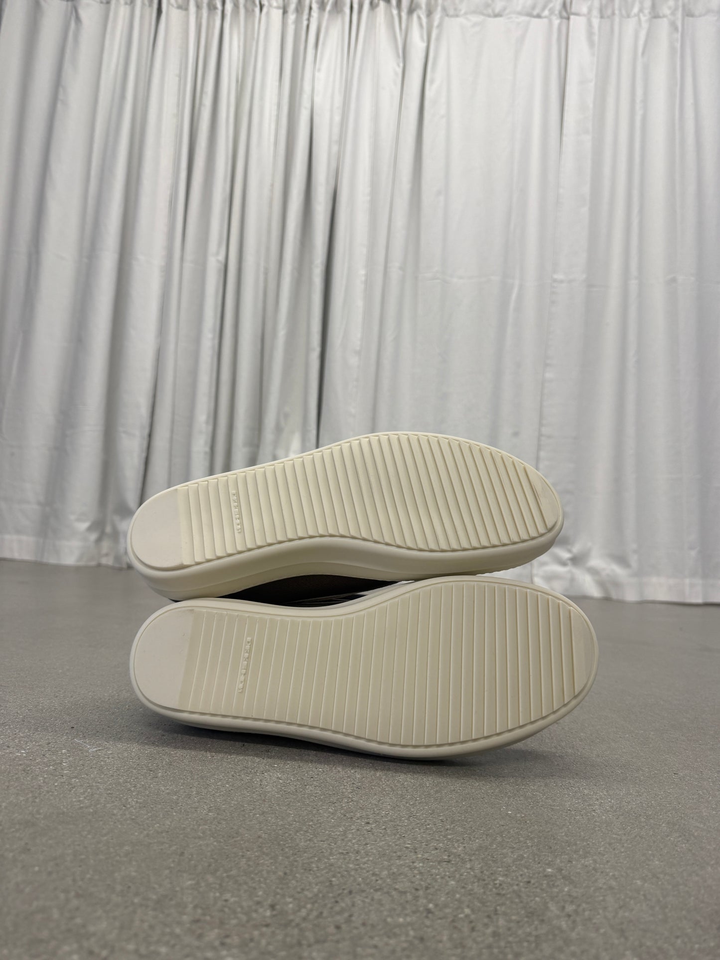 Rick Owens DRKSHDW Dust sneakers sole-up view showing cream ribbed rubber outsoles with branding
