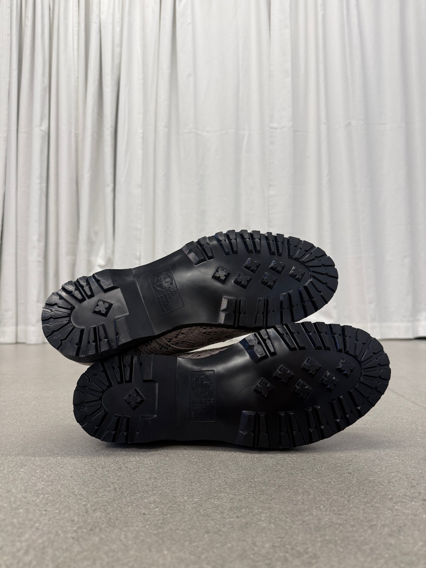 Supreme Dr Martens Postal snakeskin shoe outsoles showing black commando lug tread and embossed branding