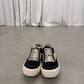 Rick Owens DRKSHDW black Vintage sneakers front view on concrete floor showing white toe cap and waxed laces.