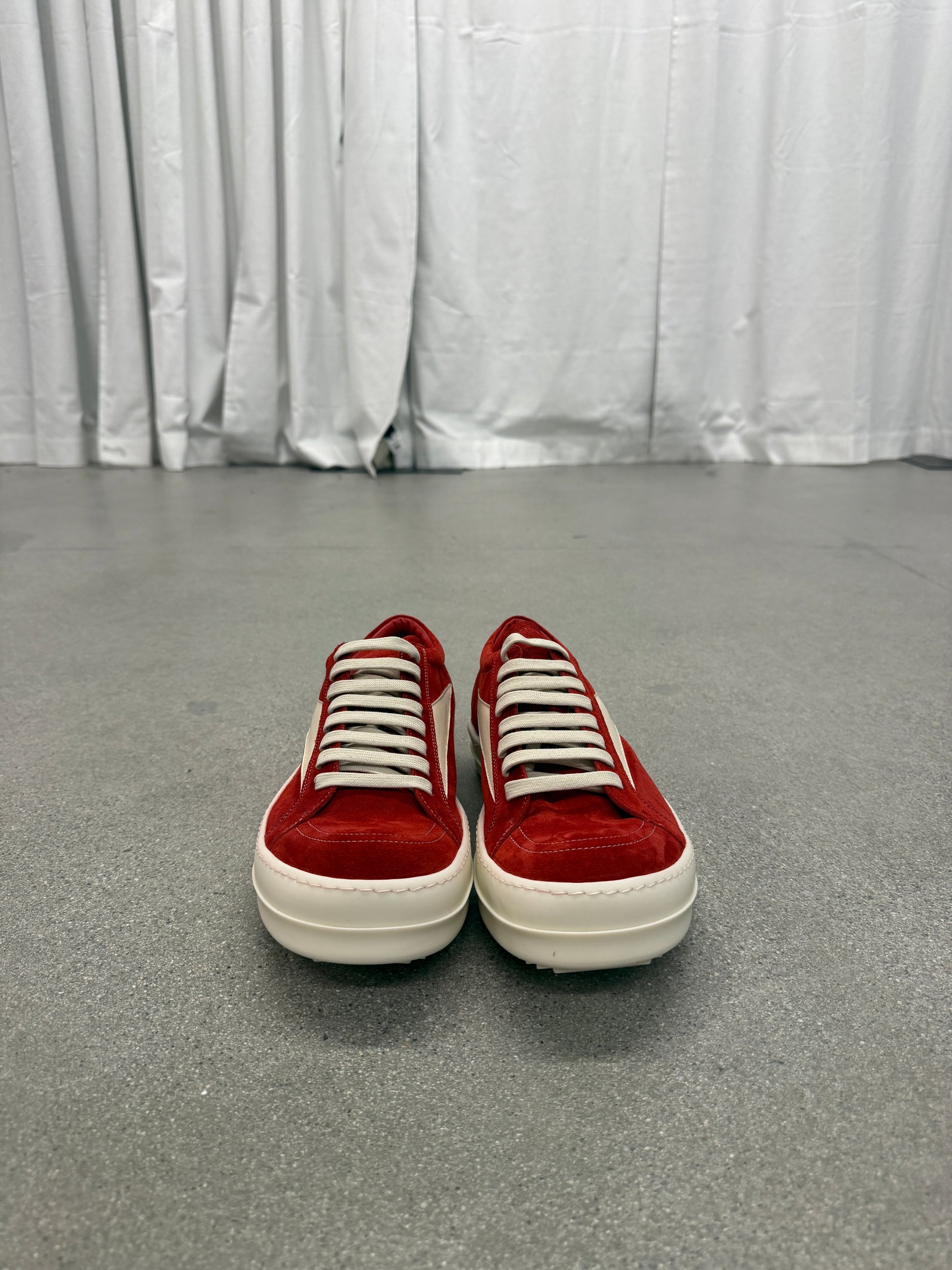 Side profile of Rick Owens Carnelian sneakers in aged grey leather with extended toe and rubber wrap sole.