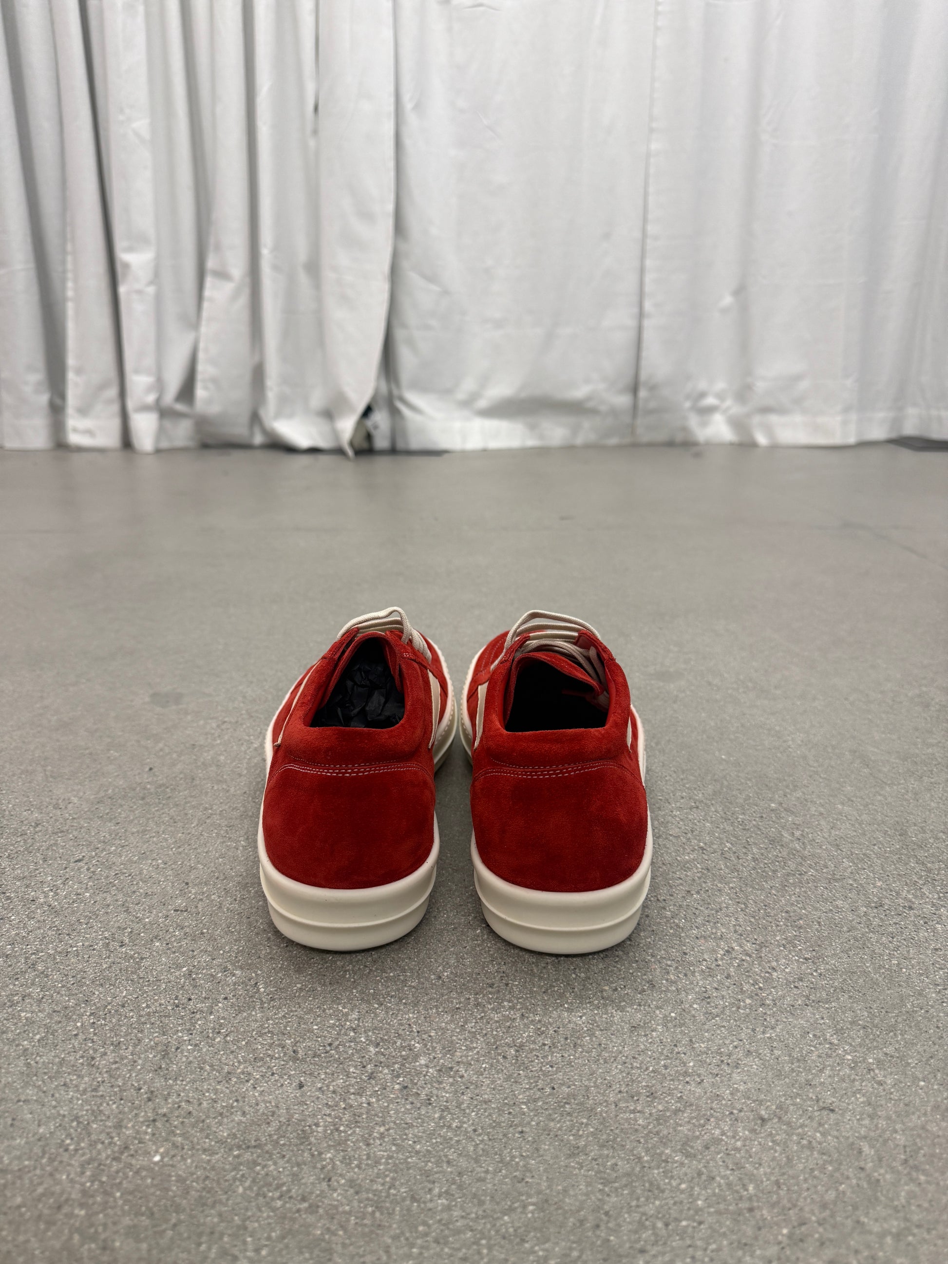 Rick Owens Carnelian sneakers shown from rear angle highlighting elongated heel and distressed patina.