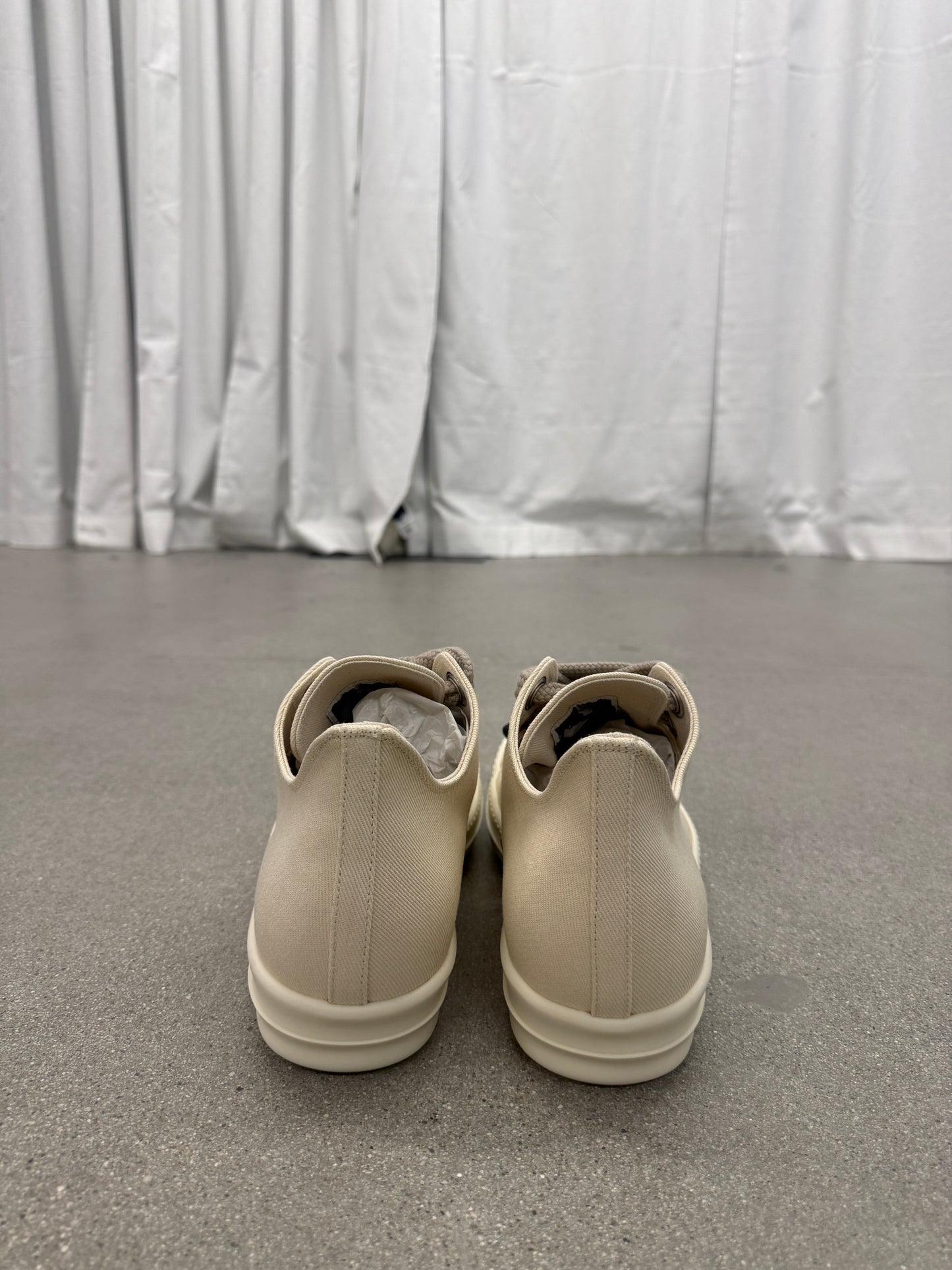 Heel view of Rick Owens DRKSHDW milk low-top sneakers showing smooth leather backs and chunky white sole