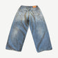 Acne Studios paint splatter loose jeans back, faded wide-leg denim with leather logo patch and distress markings.