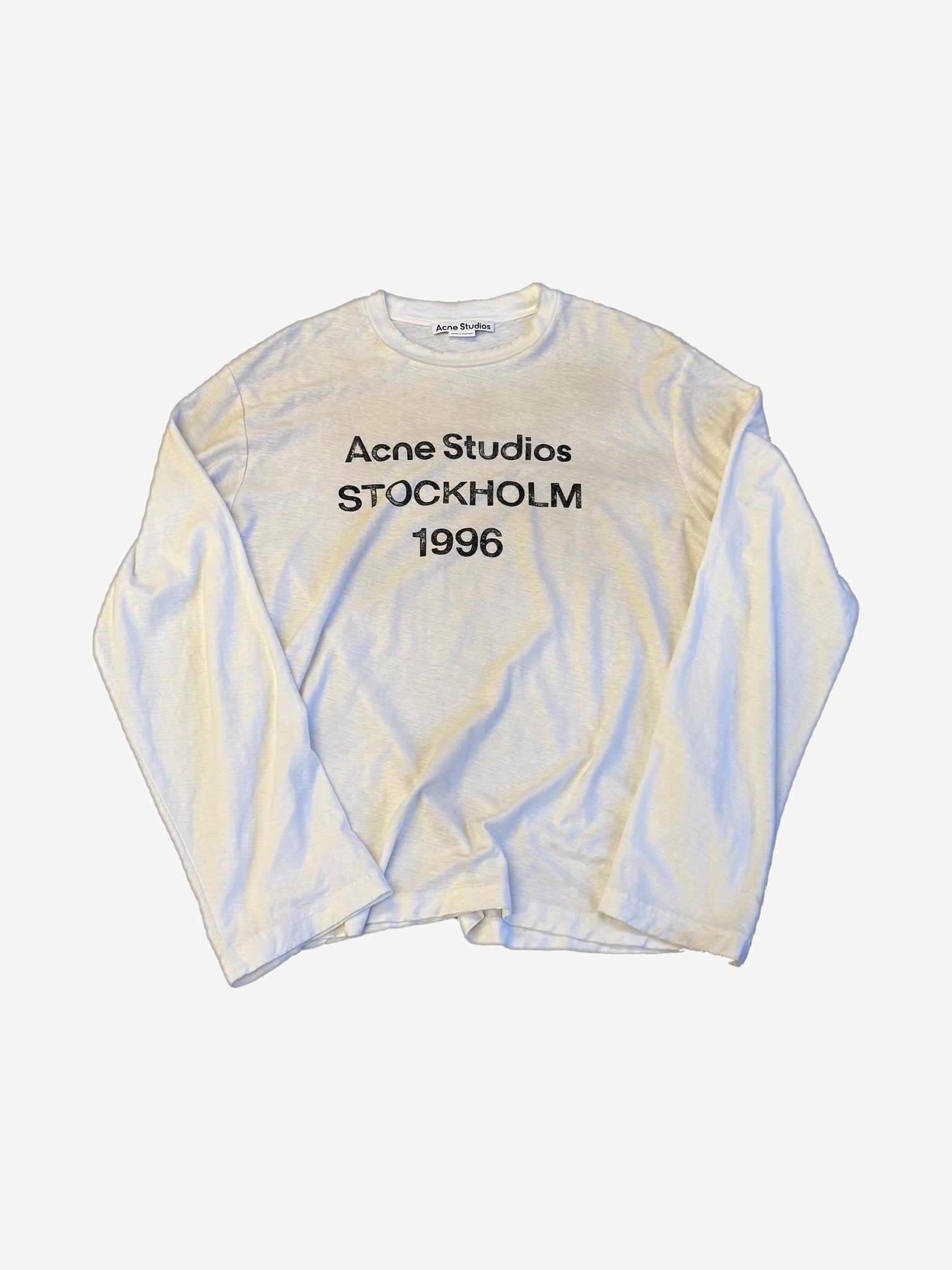 Acne Studios dusty white cotton longsleeve tee with tonal printed logo at chest and relaxed boxy fit.