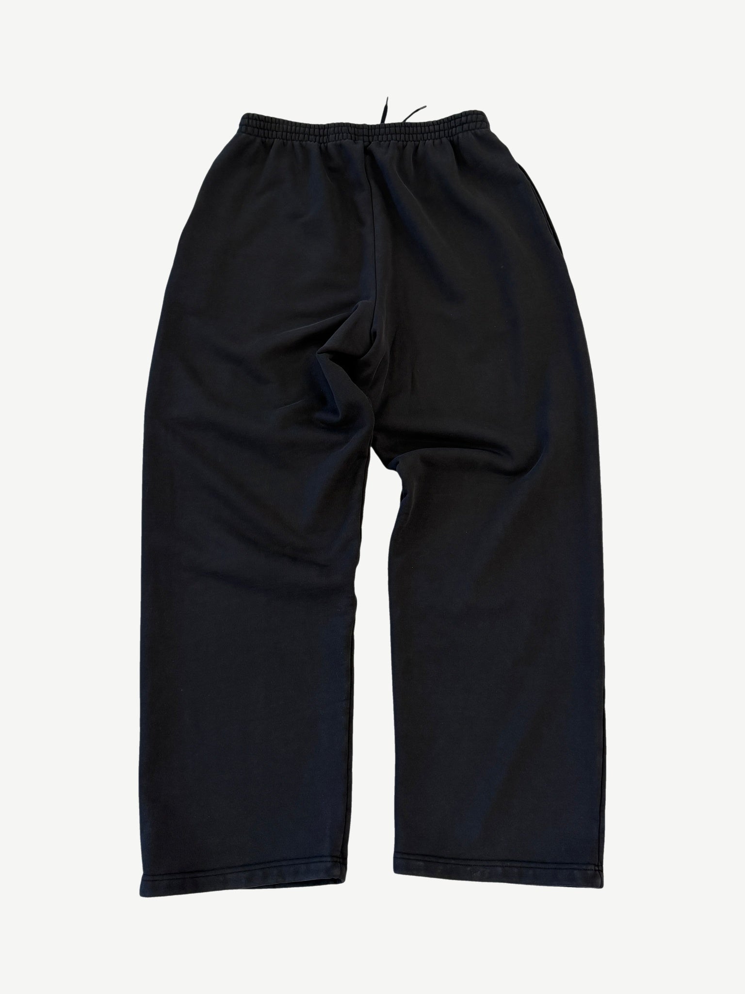 Back of Balenciaga 3M black sweatpants with elastic cuffs, side pockets and tapered relaxed silhouette.