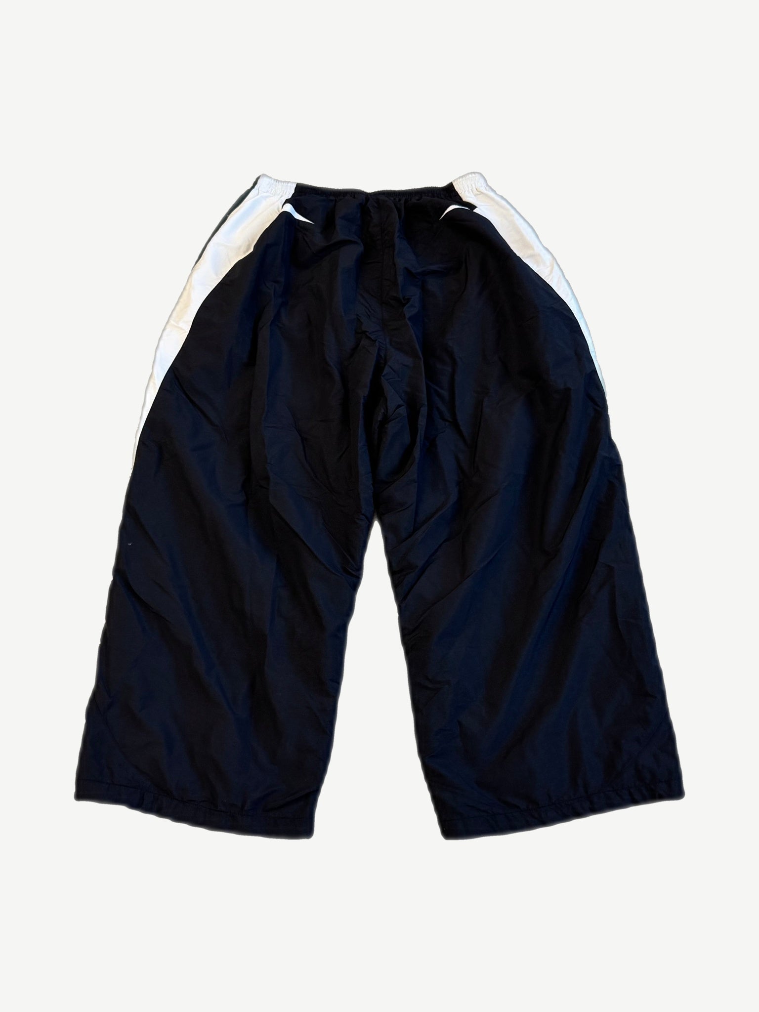 Balenciaga black 3B Sports Icon trackpants back view, baggy nylon with curved white side panels at hip