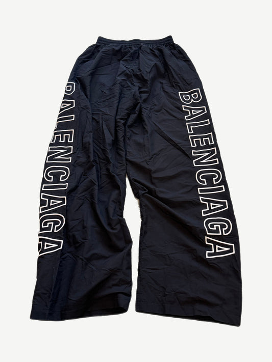 Balenciaga black nylon trackpants with white outline BALENCIAGA wordmark printed down the left leg.