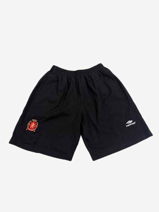 Balenciaga black athletic soccer shorts with white embroidered crest logo on left thigh, front view