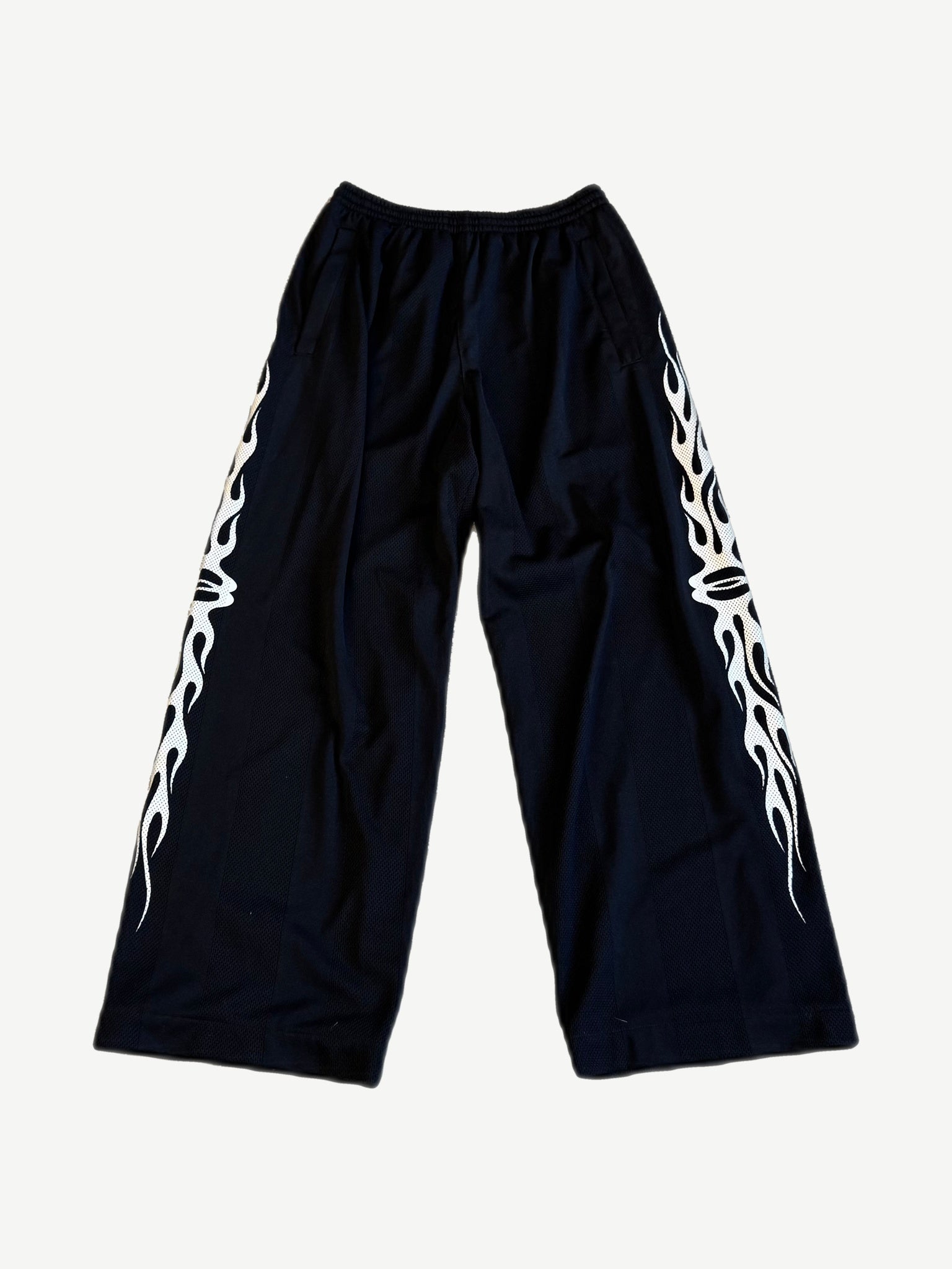 Balenciaga Burning Unity wide-leg black mesh pants with white tribal flame side panel print