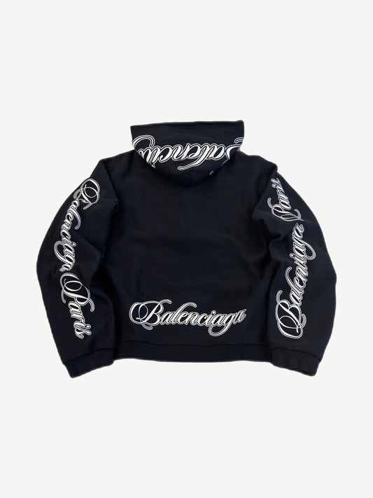 Balenciaga black zip hoodie back with large white Balenciaga cursive script across shoulder blades
