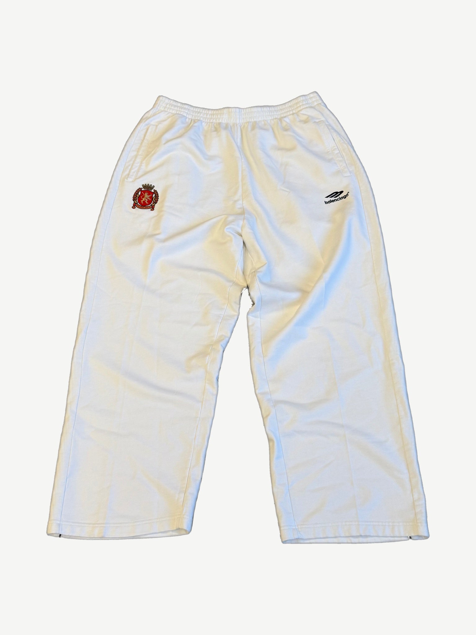 Balenciaga white cotton sweatpants with embroidered red lion soccer crest and Balenciaga wing logo on hip