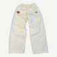 Balenciaga white cotton track pants front with embroidered soccer crest patch and elastic waistband.