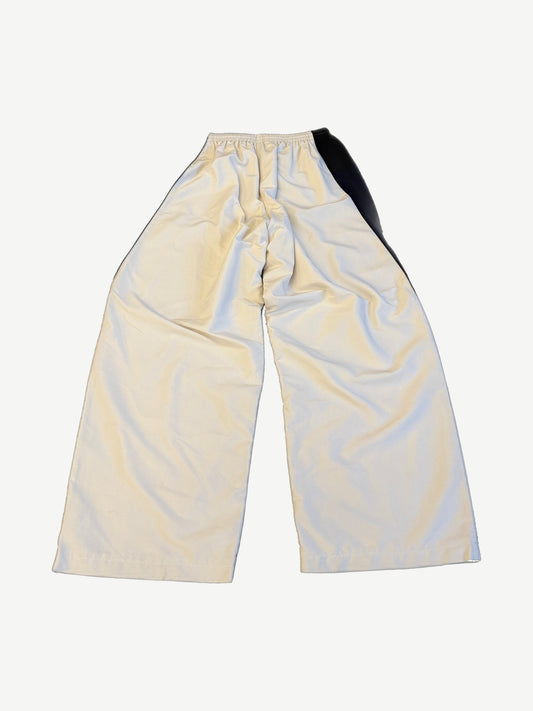 Balenciaga white tracksuit pants back view showing wide leg drape and contrast black side panel.