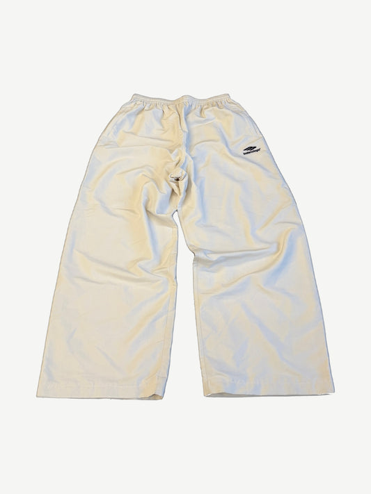 Balenciaga white tracksuit pants in cream nylon with embroidered Balenciaga logo on hip and elastic waist.