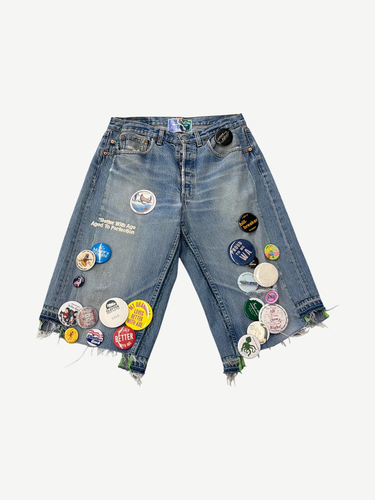 Better With Age denim jean shorts front view, raw frayed hem with scattered enamel pin details