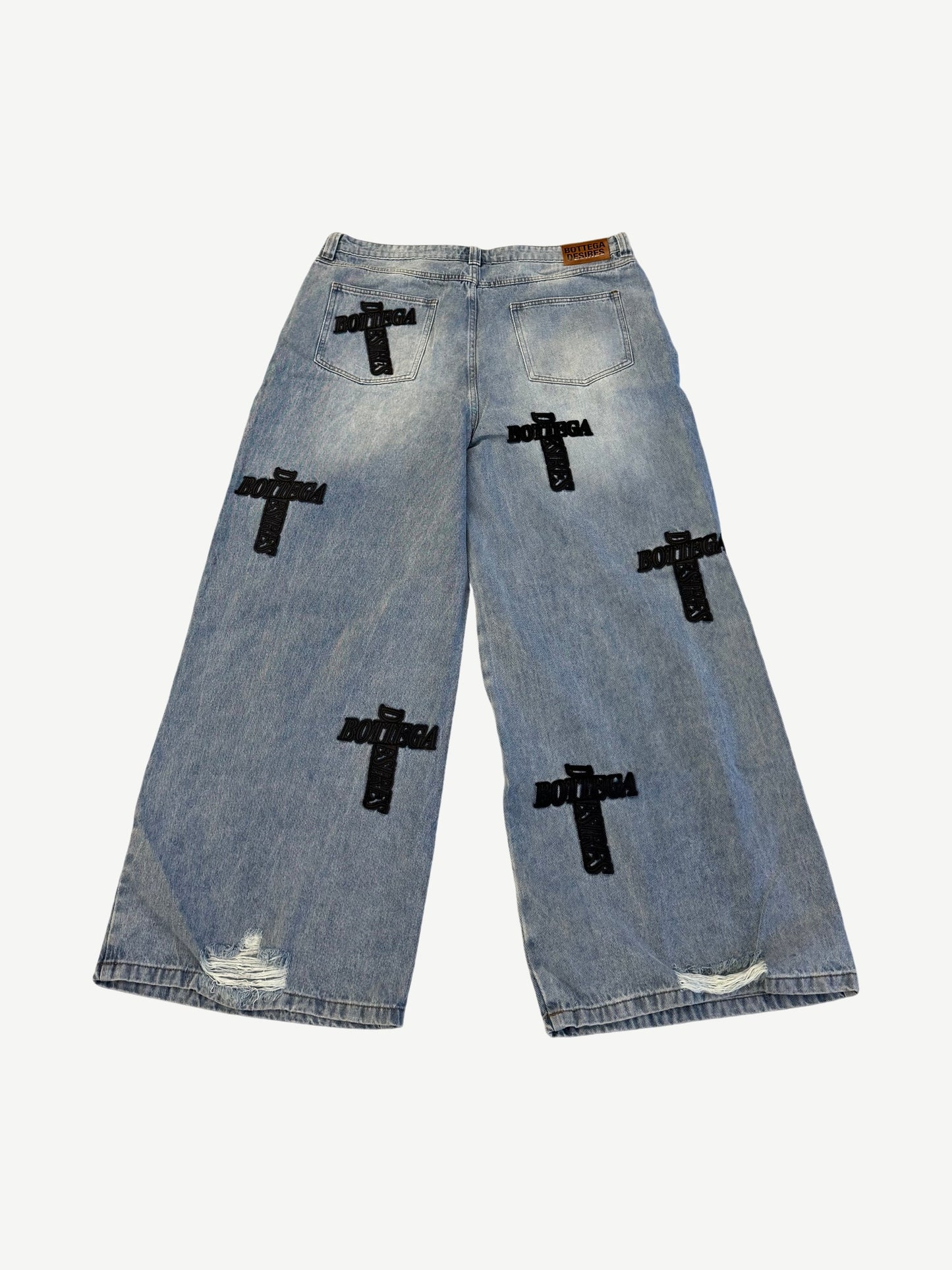 Back view of Bottega Desires blue Holy Grail jeans with leather rear patch and black embroidered cross logos