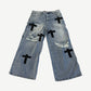 Bottega Desires light blue wide-leg distressed jeans with black Bottega cross patches scattered across legs