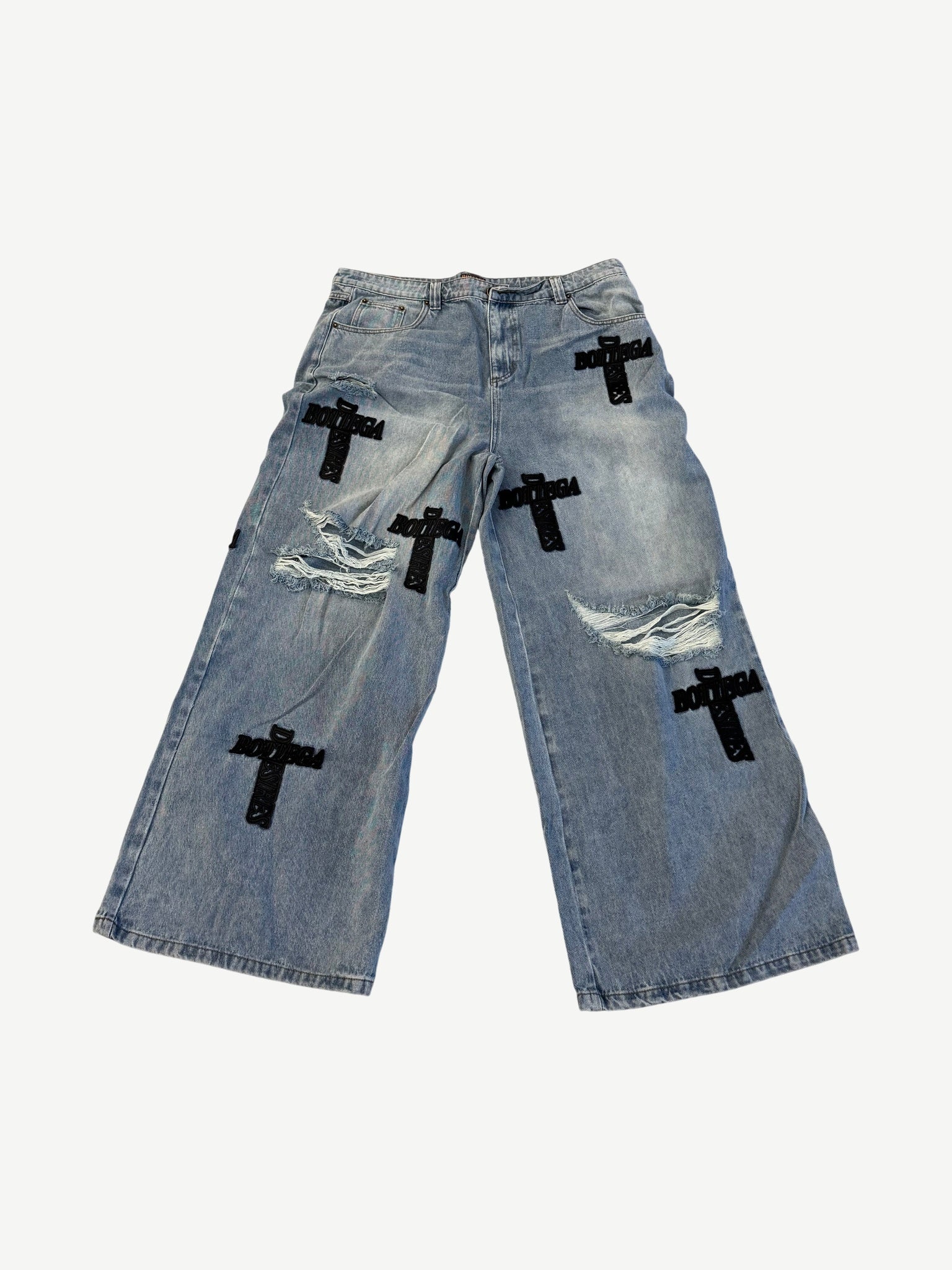 Bottega Desires light blue wide-leg distressed jeans with black Bottega cross patches scattered across legs