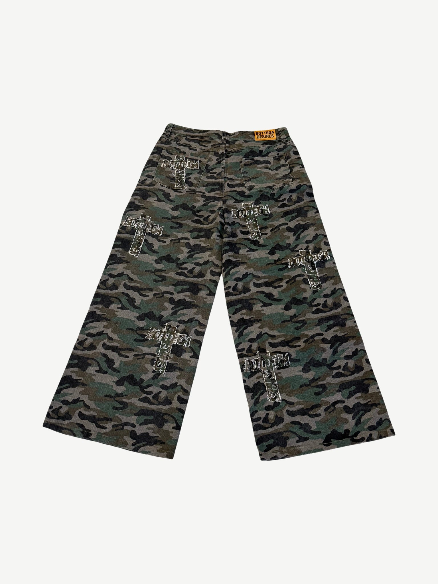 Bottega Desires camo denim back view with orange brand tab and embroidered cross patches scattered across legs